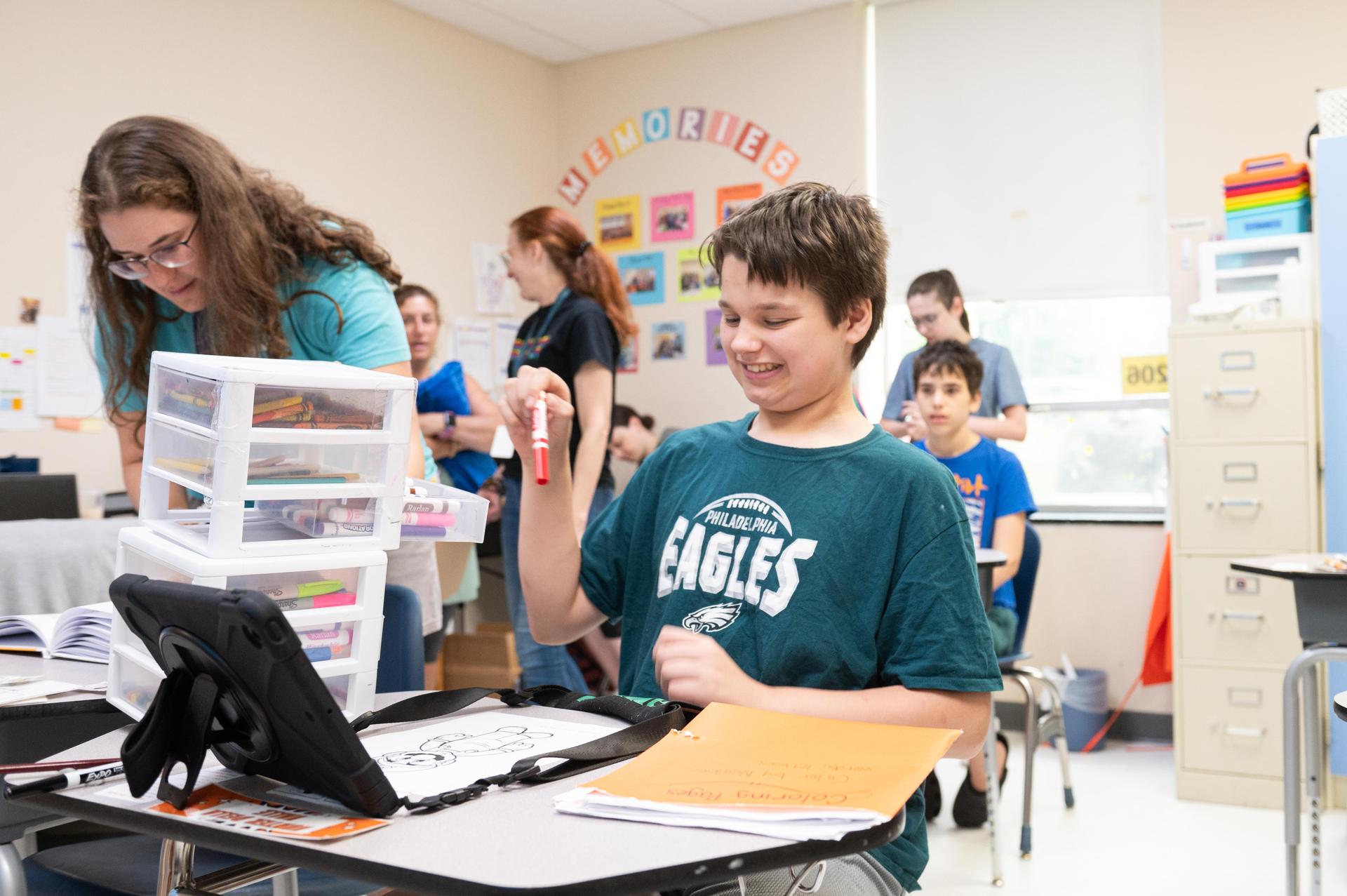 Boy at desk working on ipad.