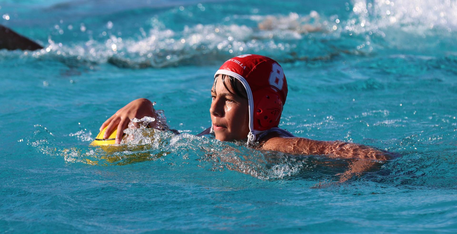 boys water polo players in action against hoover