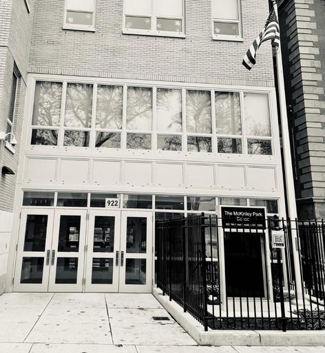Black and white image of a building entrance with large windows and two doors.