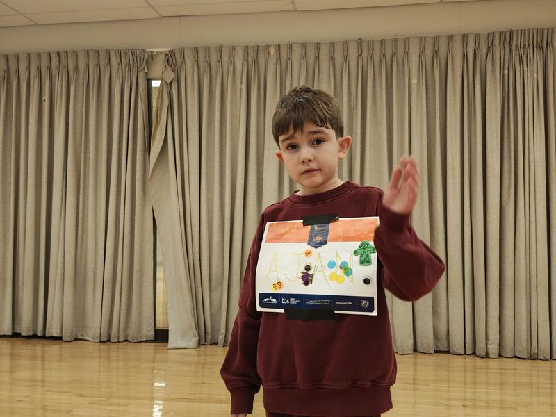 Student standing with rising road runner sign