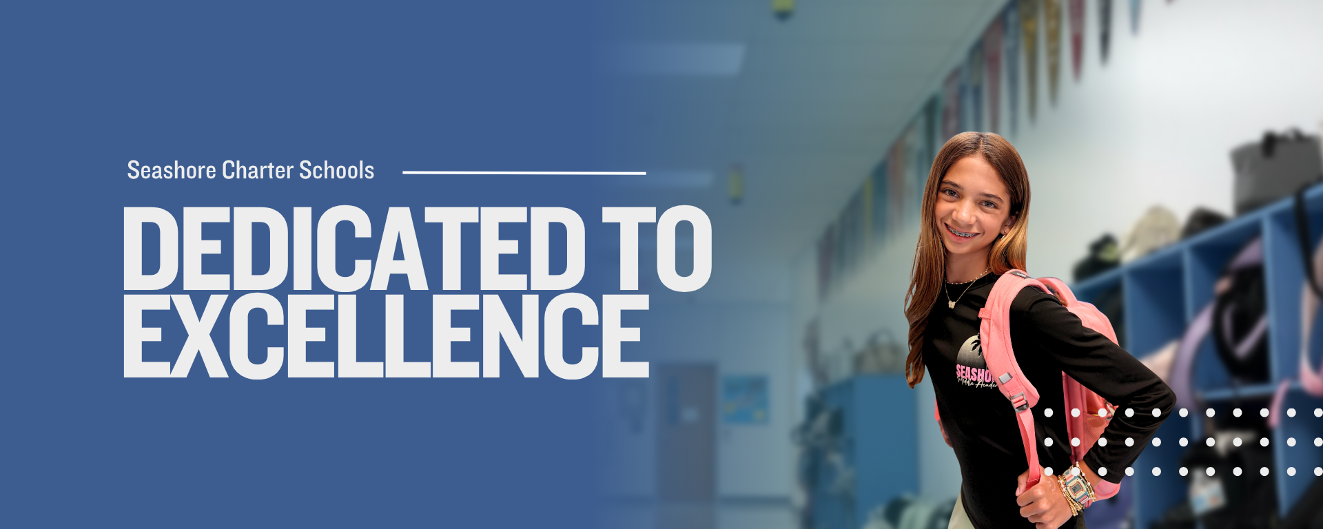 A student in a sports jersey smiles in a school hallway with lockers.