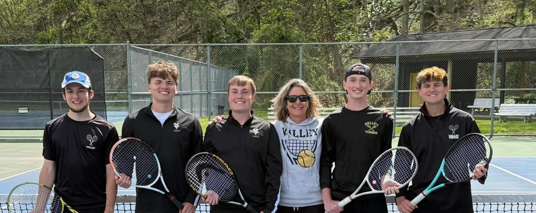 Boys tennis team posing for a picture with their coach.