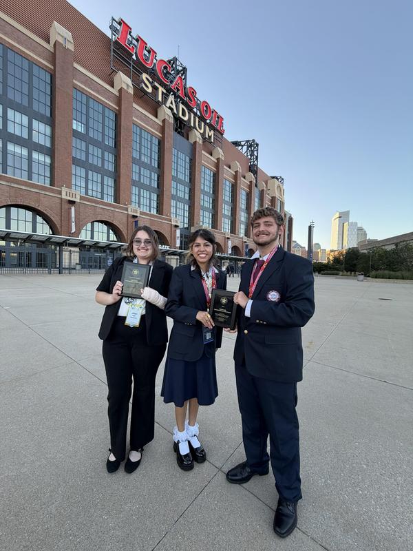 3 students holding award