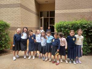 2nd grade girls pose with their first day of chumash badges