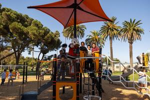 Wild Wing with students on the playground under an orange canopy.