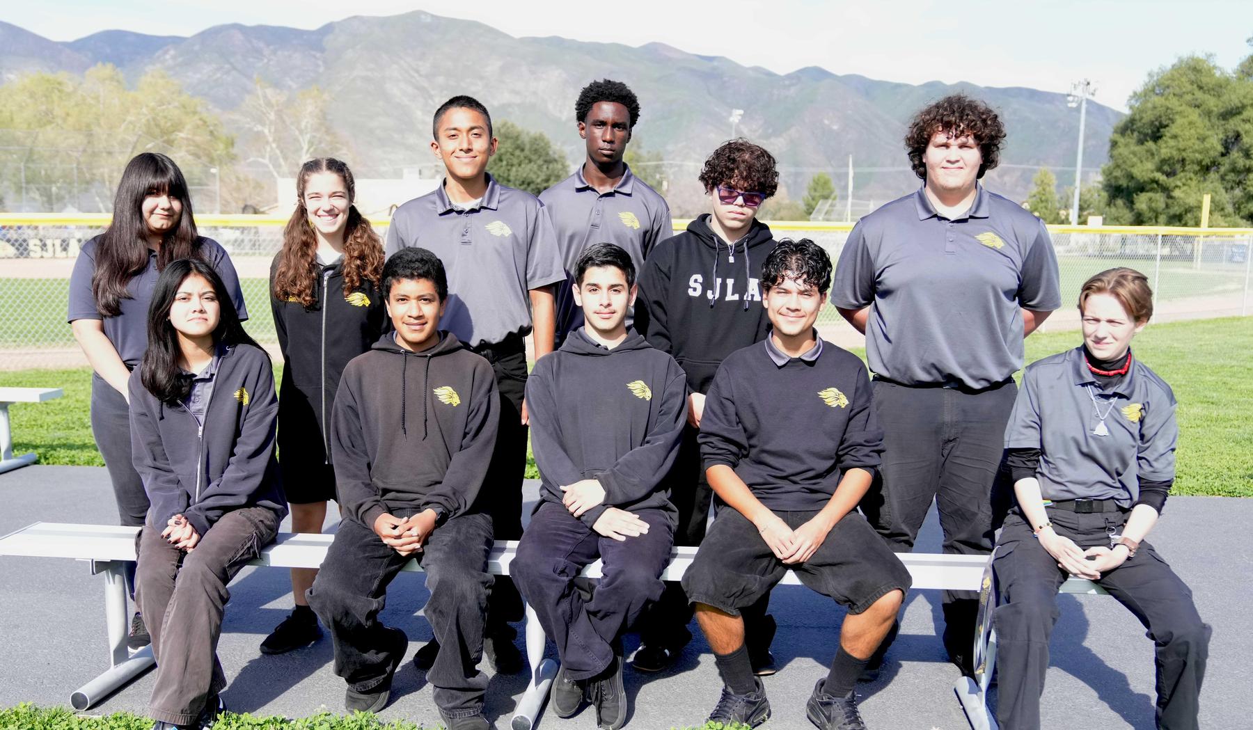 Group of students posing together outdoors in sports attire.
