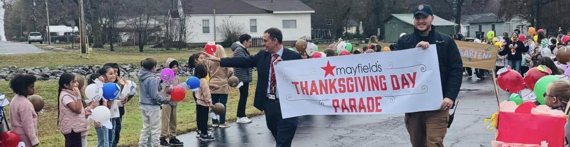 Mr. Edwards and Officer Crane carried the Mayfield's Thanksgiving Day Parade banner to start the parade.