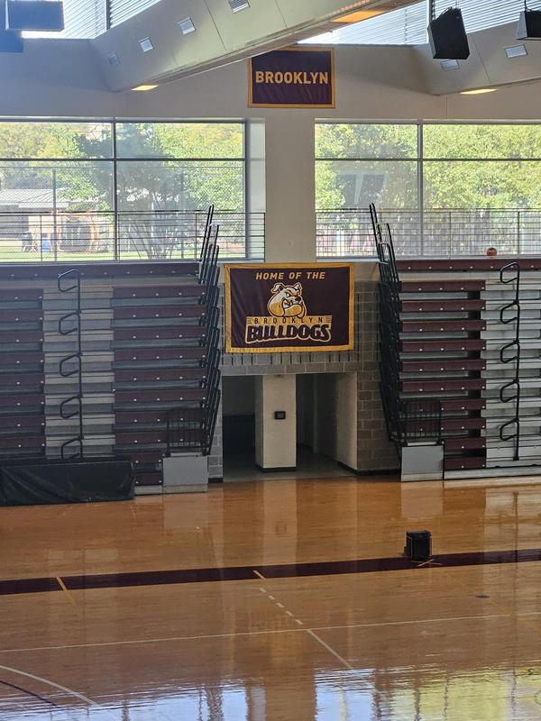Indoor gym with a banner reading 'Home of the Bulldogs' and bleachers.