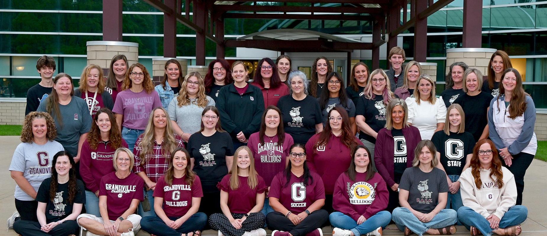 staff outside the entrance in four rows all wearing their favorite Grandville shirts