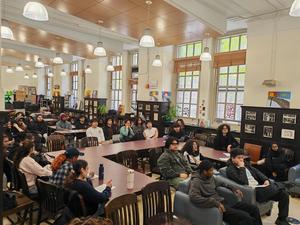 Group of students seated in a bright room during a presentation.