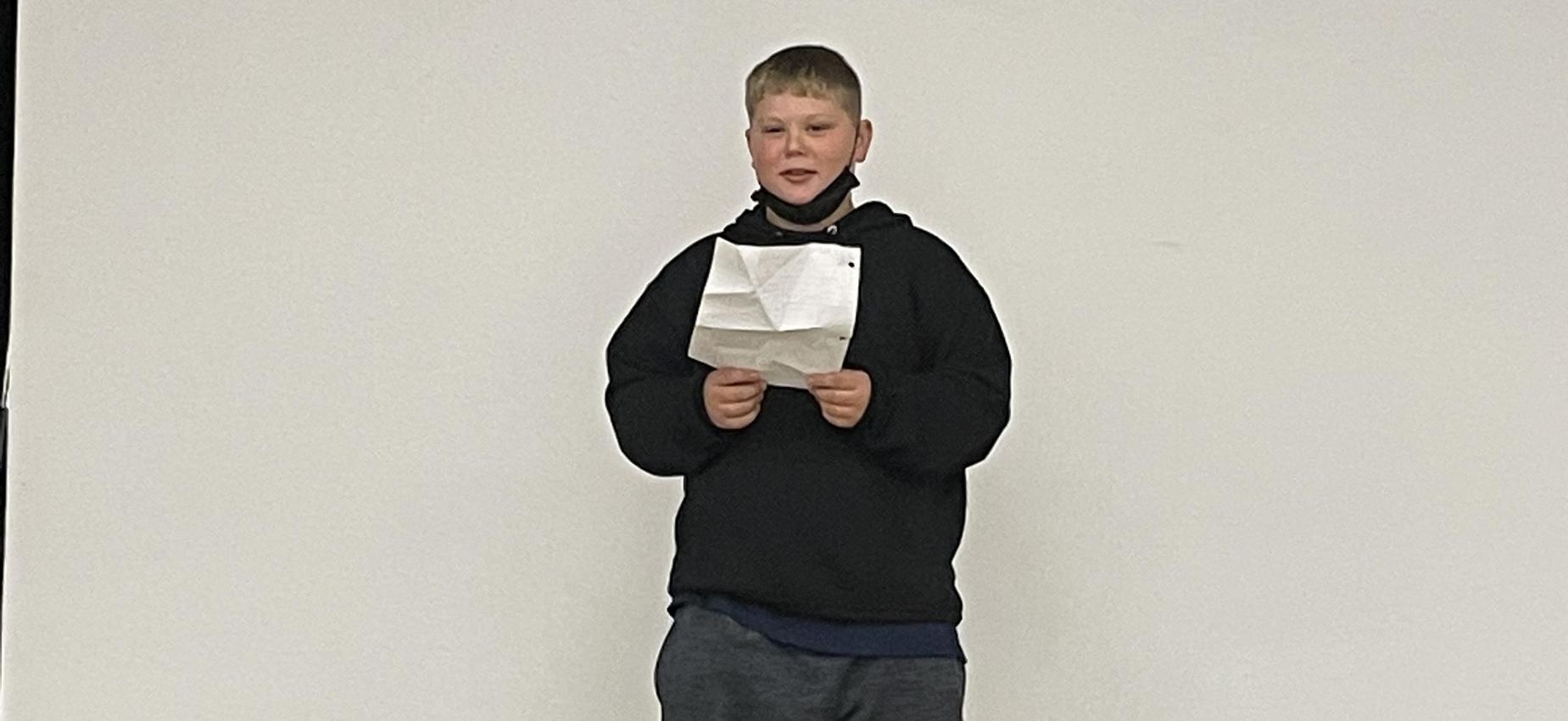 A student reads on a stage.