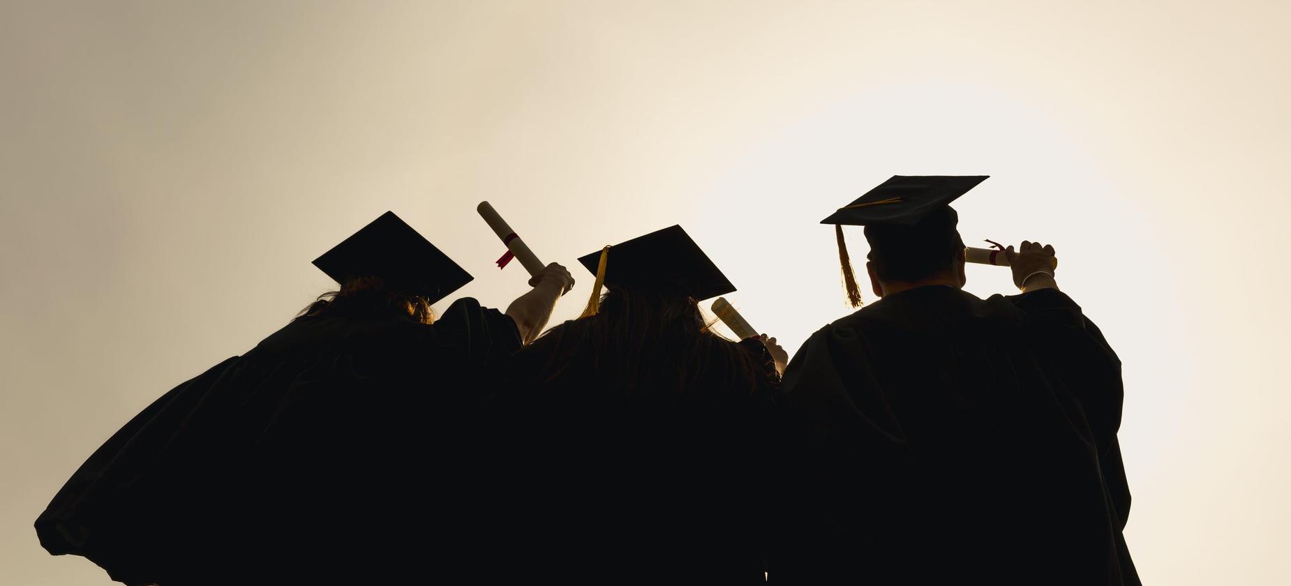 Students in graduation caps and gowns viewed from behind