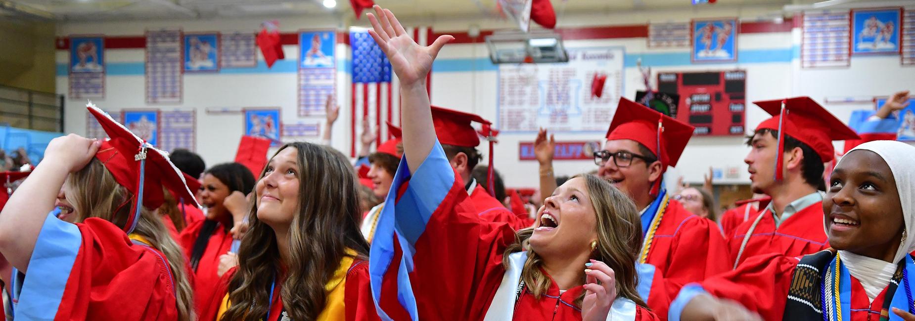 Students throwing graduation caps.