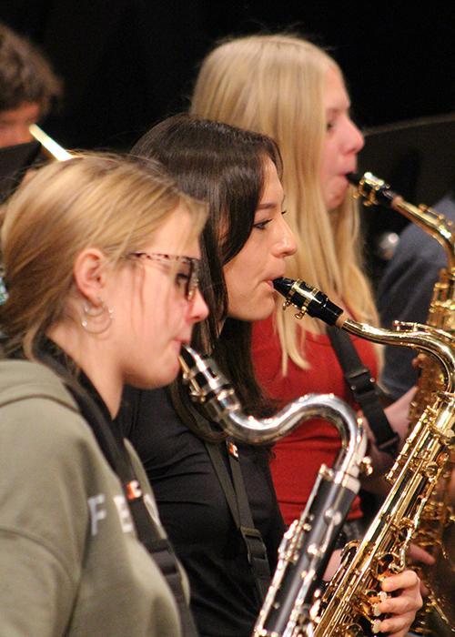 Students play saxophone.