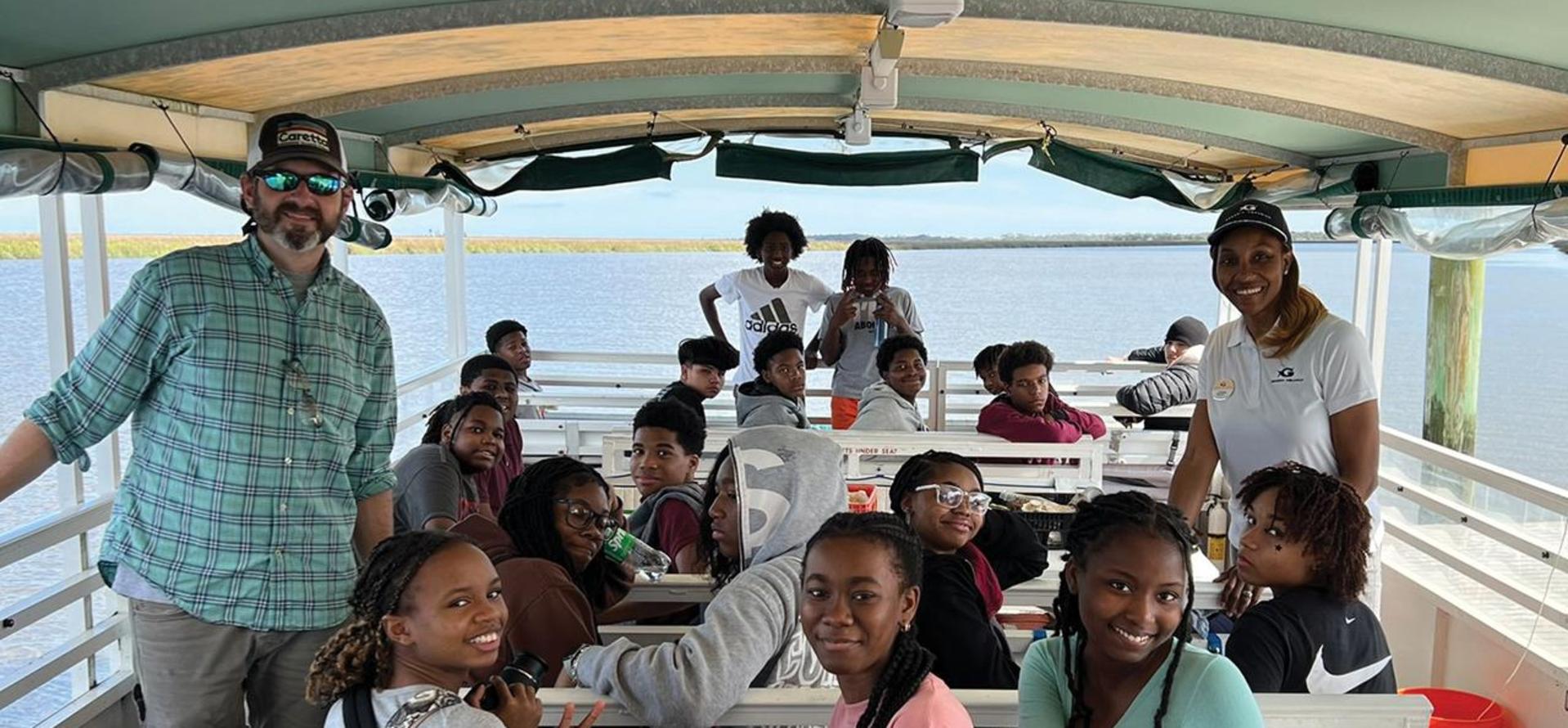 Group of Marine Science students on a boat with their teacher.
