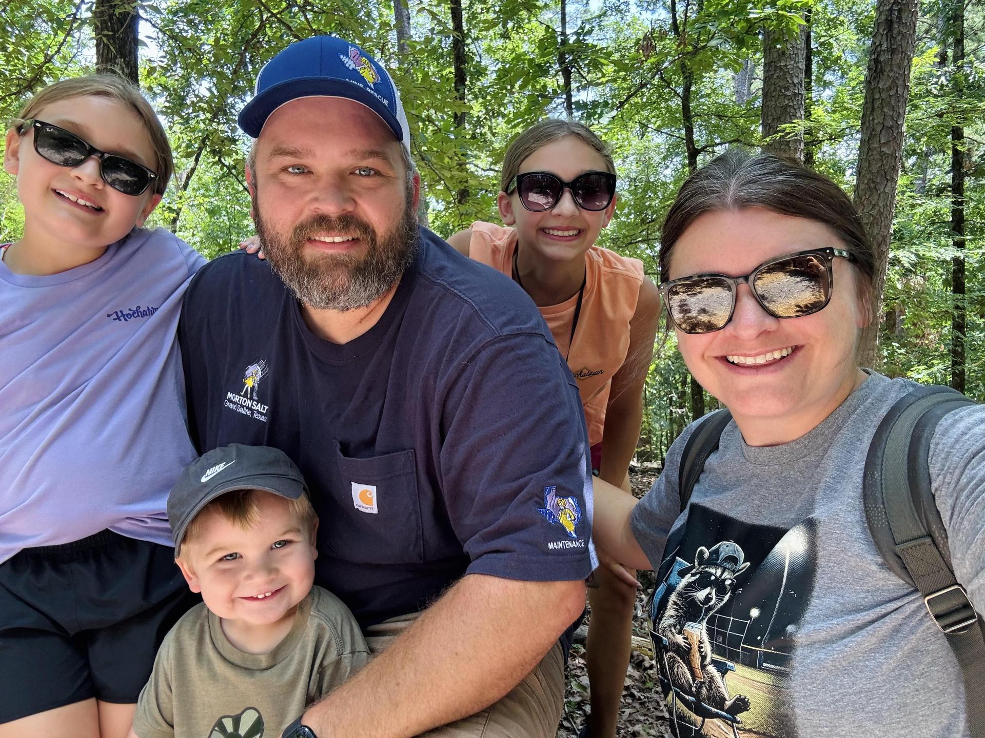 2 adults and 3 children in the woods 