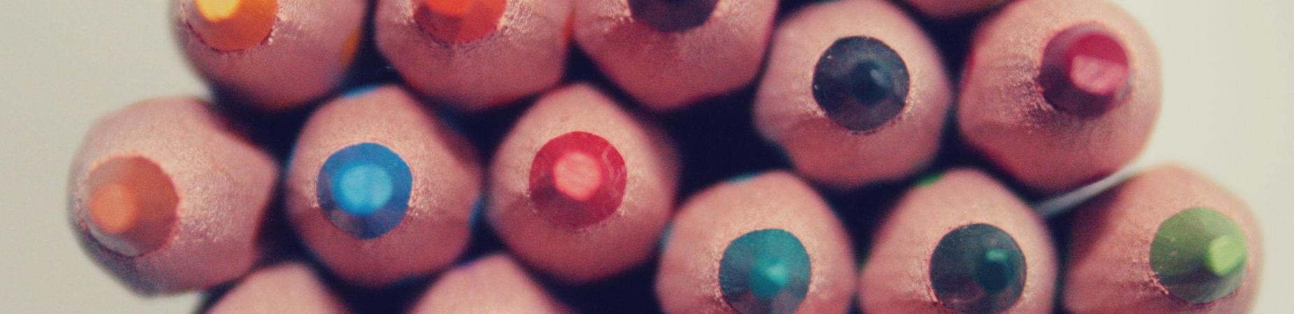 Colorful tips of sharpened colored pencils arranged in a circular formation.