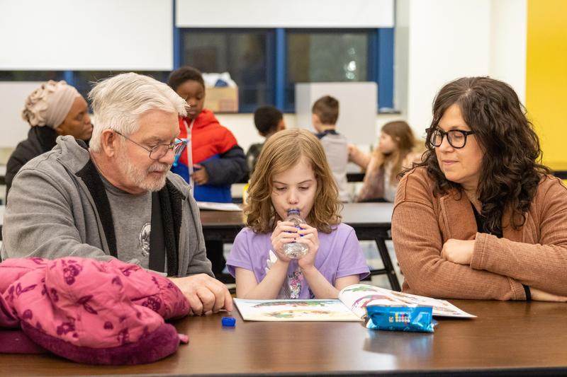 A student reads with their family at a table