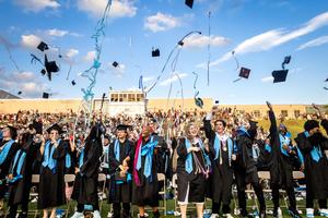 Students toss their caps into the air at graduation