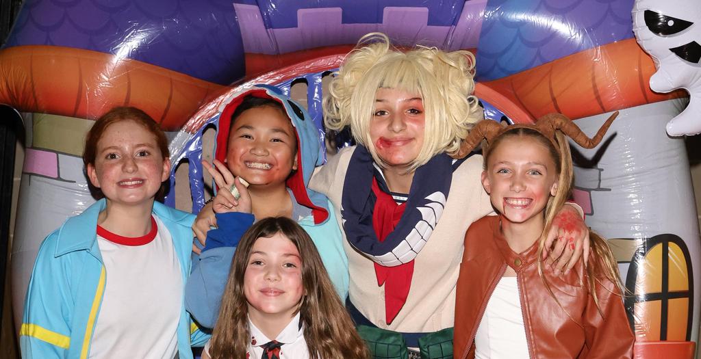 5 students with wigs and costumes at the Halloween dance.