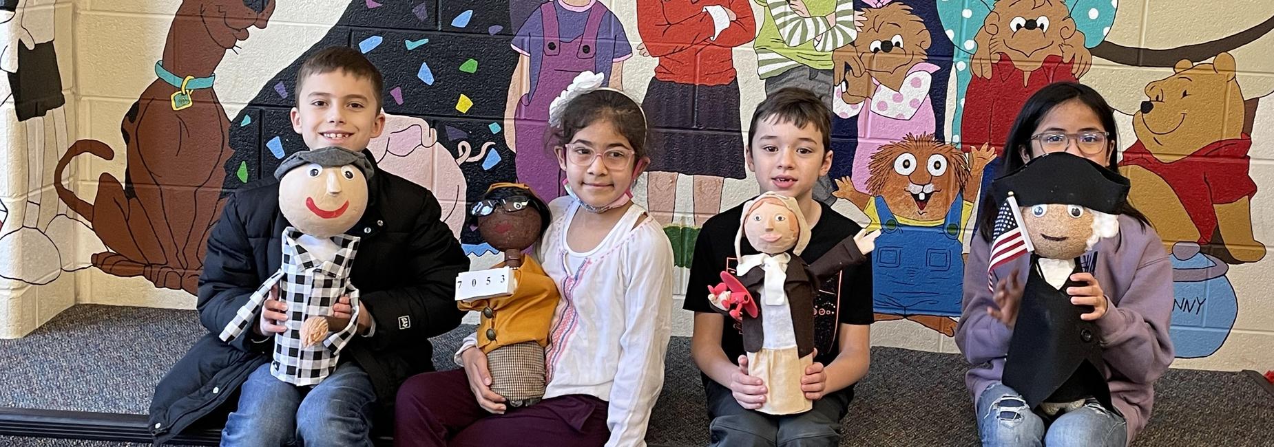 Students hold doll projects