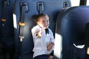 student sitting on a bus gives a thumbs up!