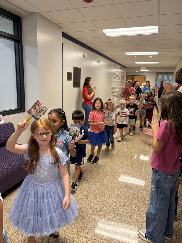 Students holding pictures of their pets