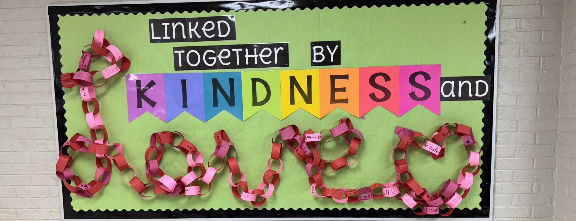 colorful display board that spells out linked together by kindness and love
