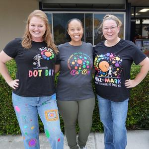 three staff members wearing Dot Day shirts