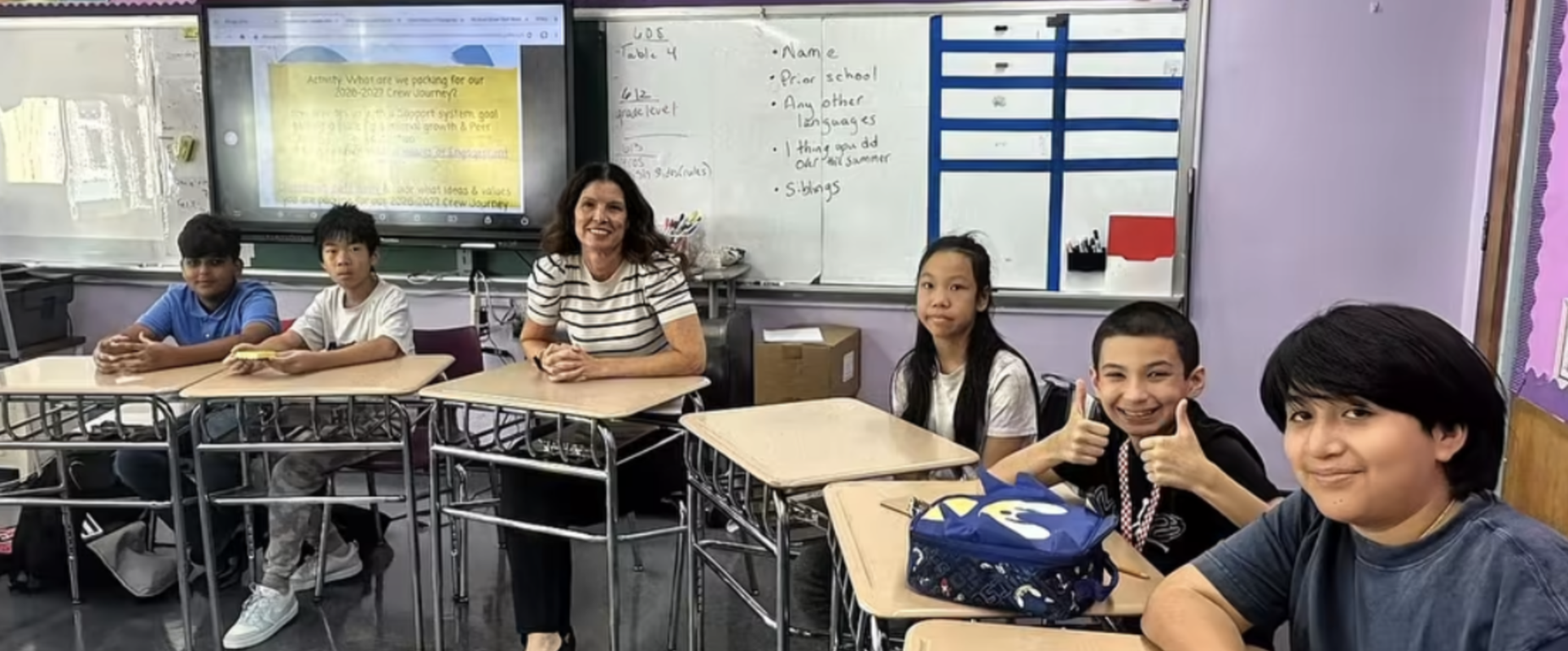students are sitting in a circle with teacher for class
