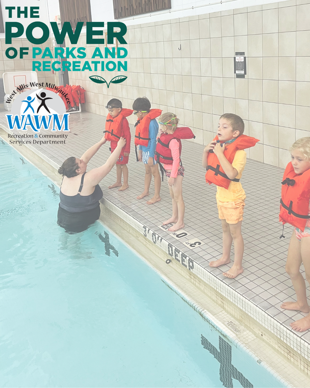 water instructor in the pool helping kids with orange life vests on