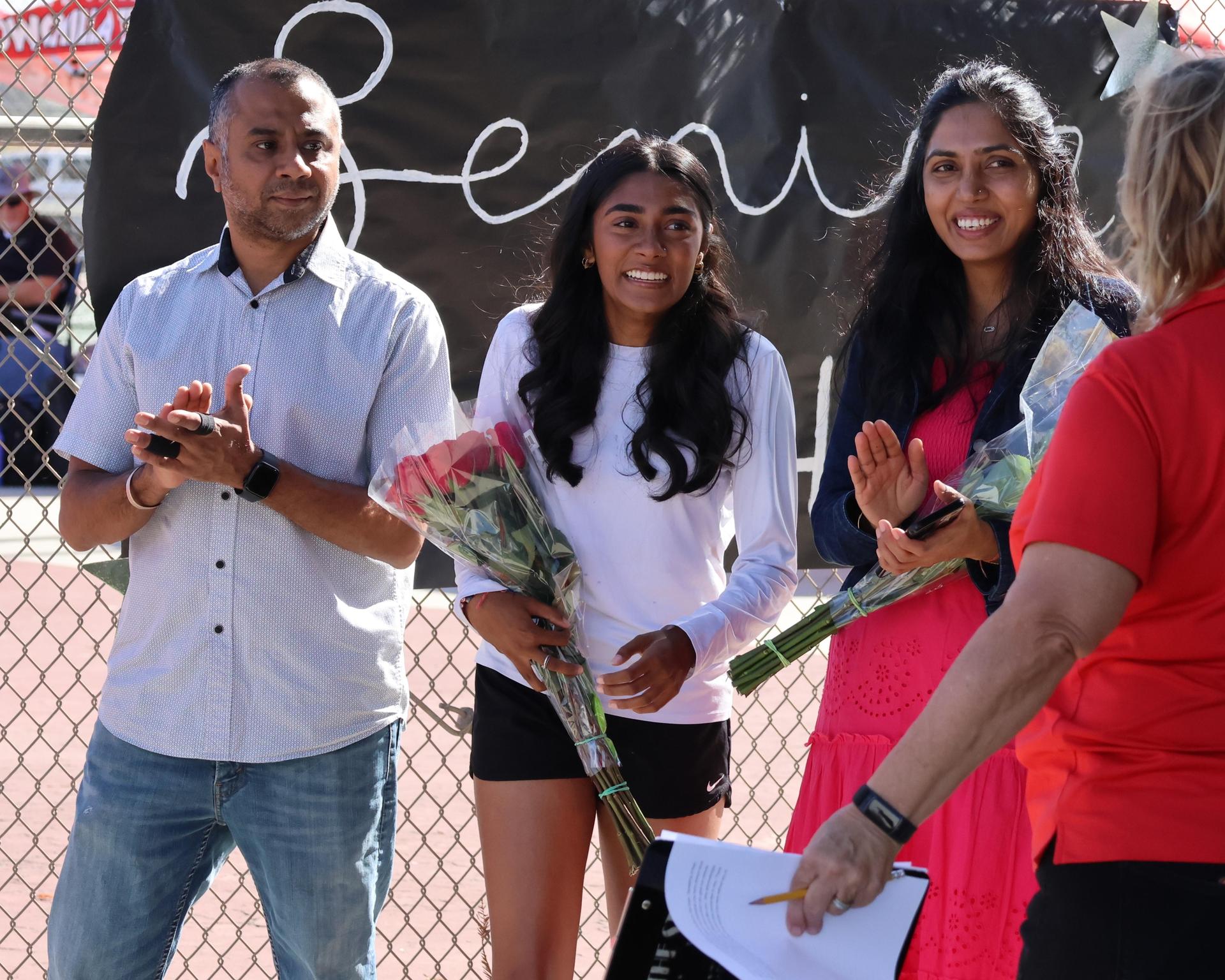 tennis players, family, and staff celebrating senior night