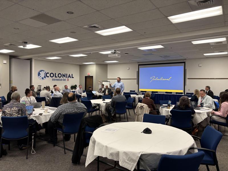 wide view of conference room with people sitting at tables
