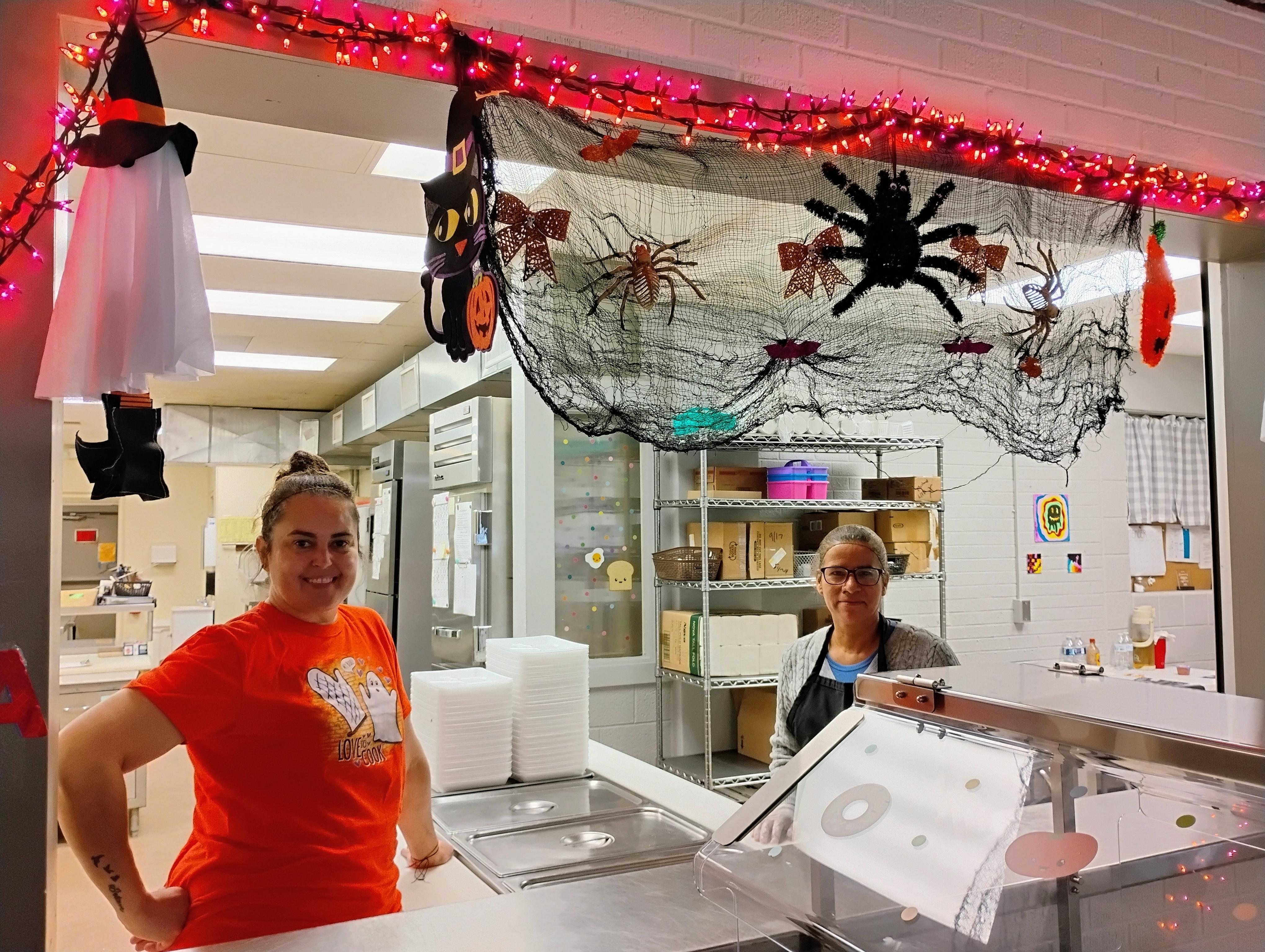 Kitchen staff with Halloween decorations above. 10/2025.