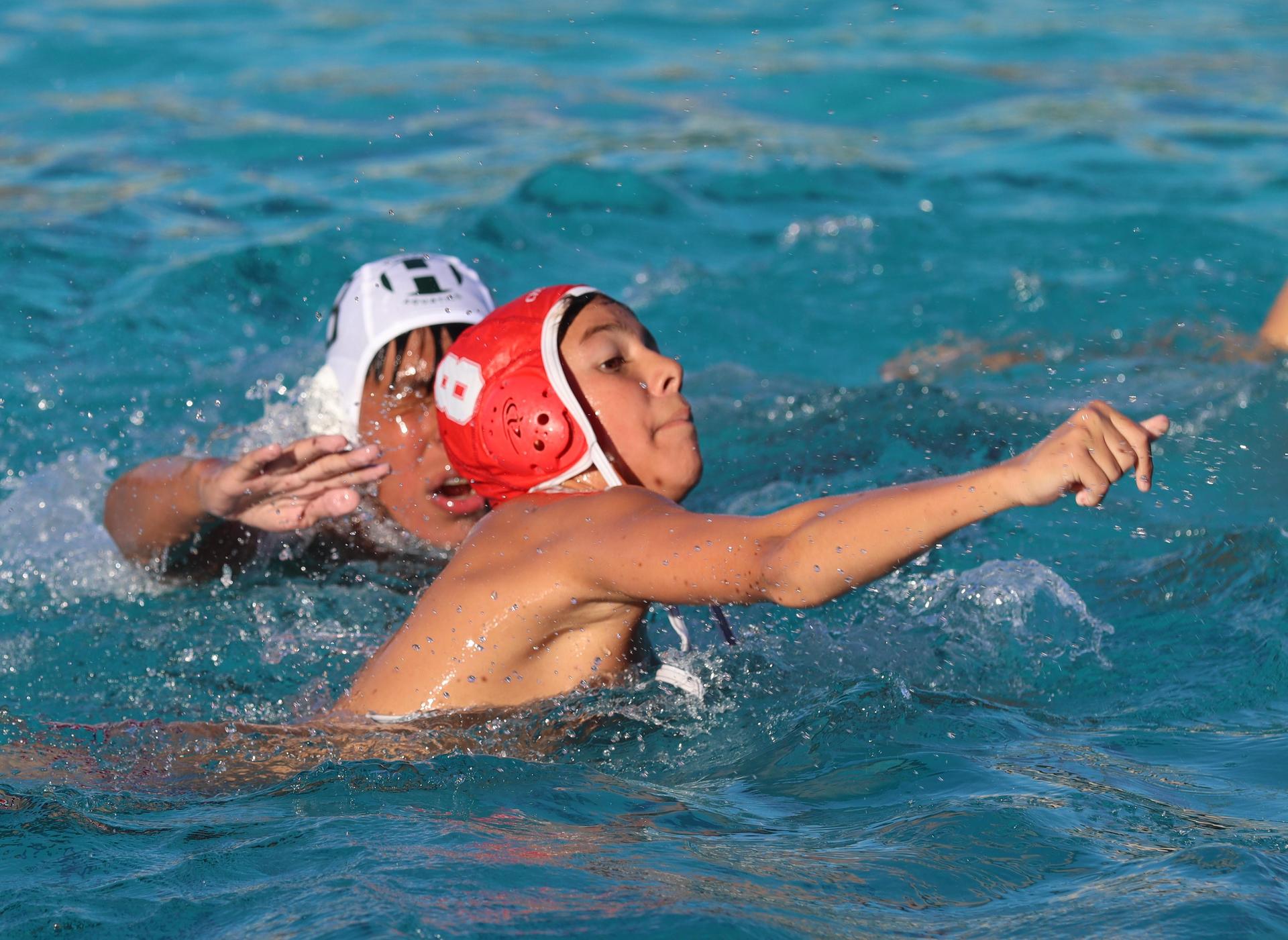 boys water polo players in action against hoover
