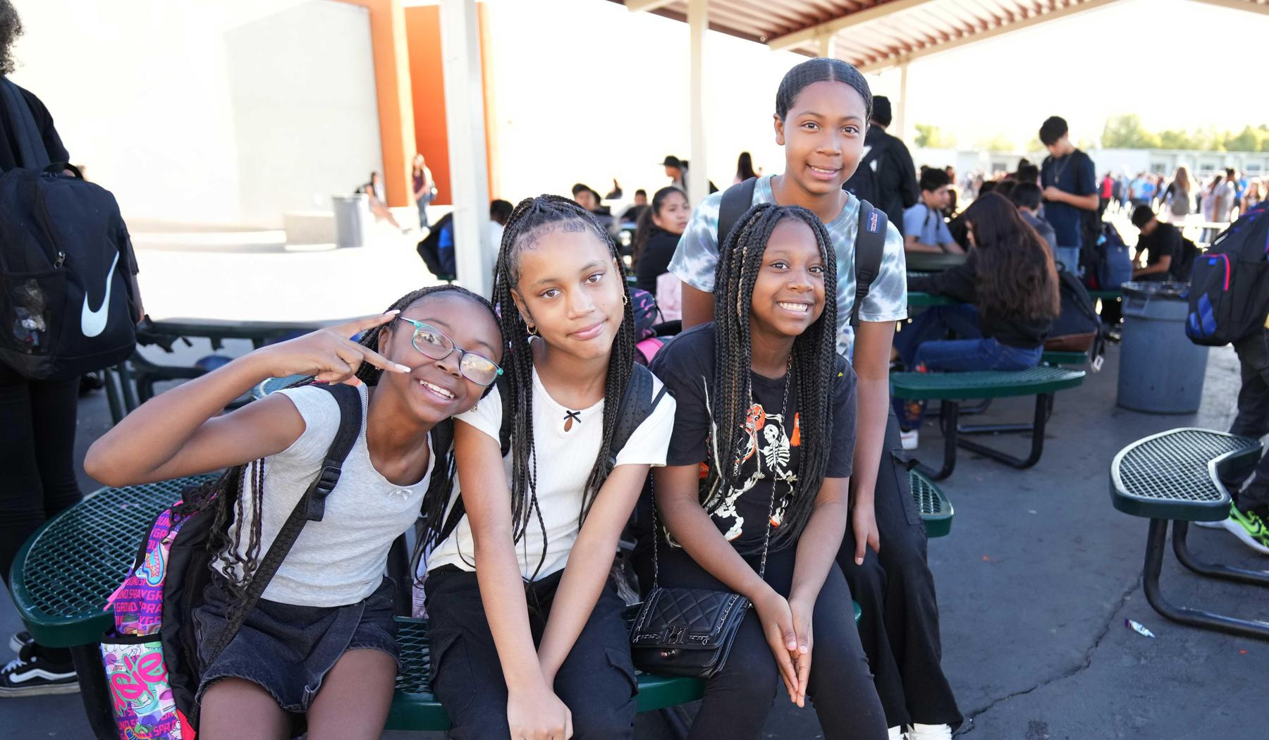 four girls sitting at outdoor picnic table