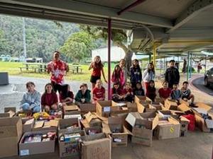 Students standin behind boxes of donated food.