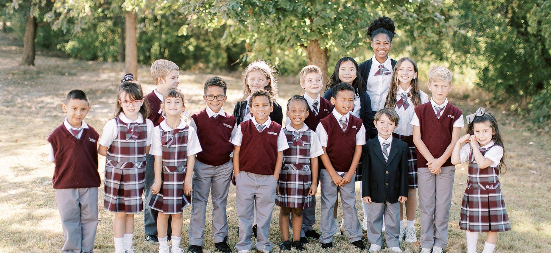 A class of Founders Classical Academy of Conroe students standing together outdoors with their teacher
