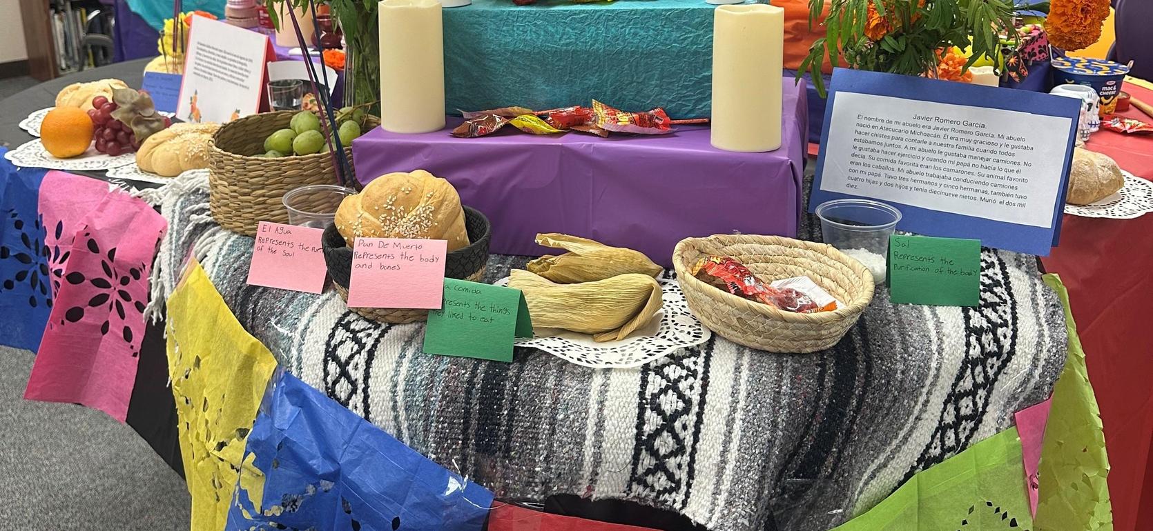 Colorful altar display with food offerings, candles, and decorations for a celebration.