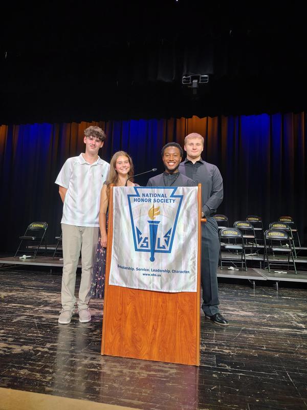 Four NHS officers stand in front of the podium.