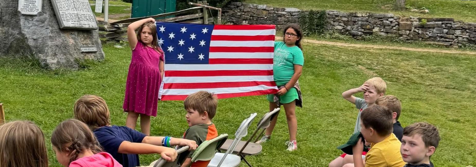 CES students holding a flag at Abingdon muster grounds