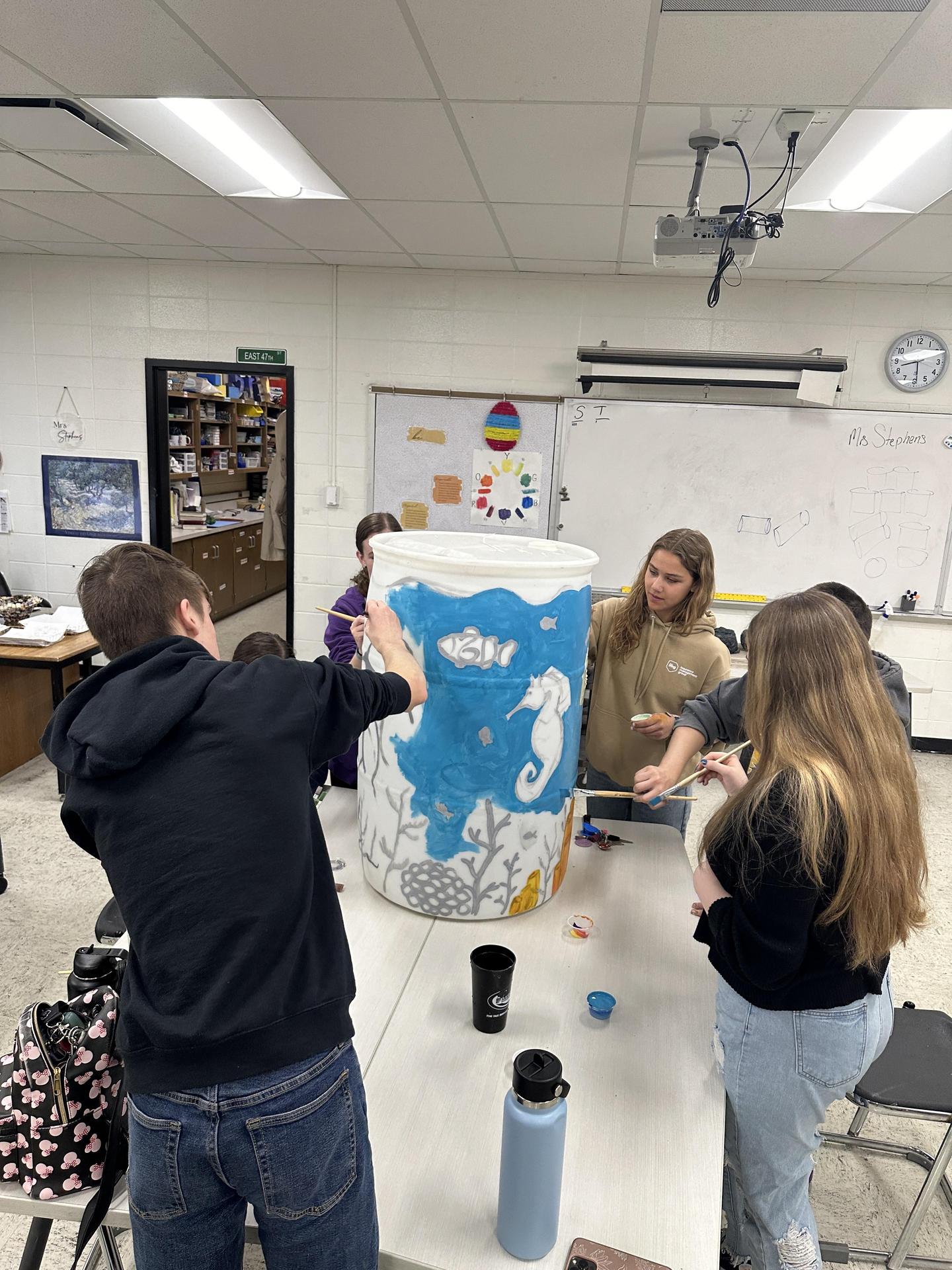 MHS National Art Honor Society members paint a rain barrel for Marion Utilities' 2024 fundraiser.