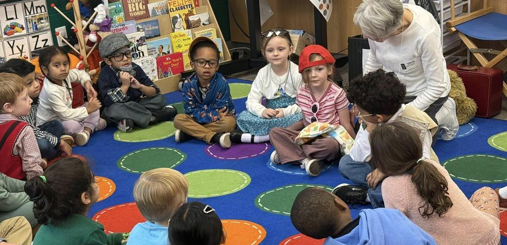 children sitting in a circle on a brightly colored carpet wearing costumes and wigs and hats