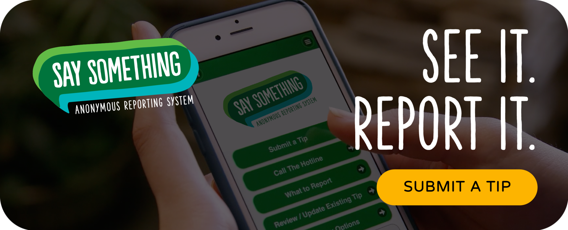 close up of hands holding a cell phone. Say Something reporting app is visible on the phone. text on image: Submit a tip