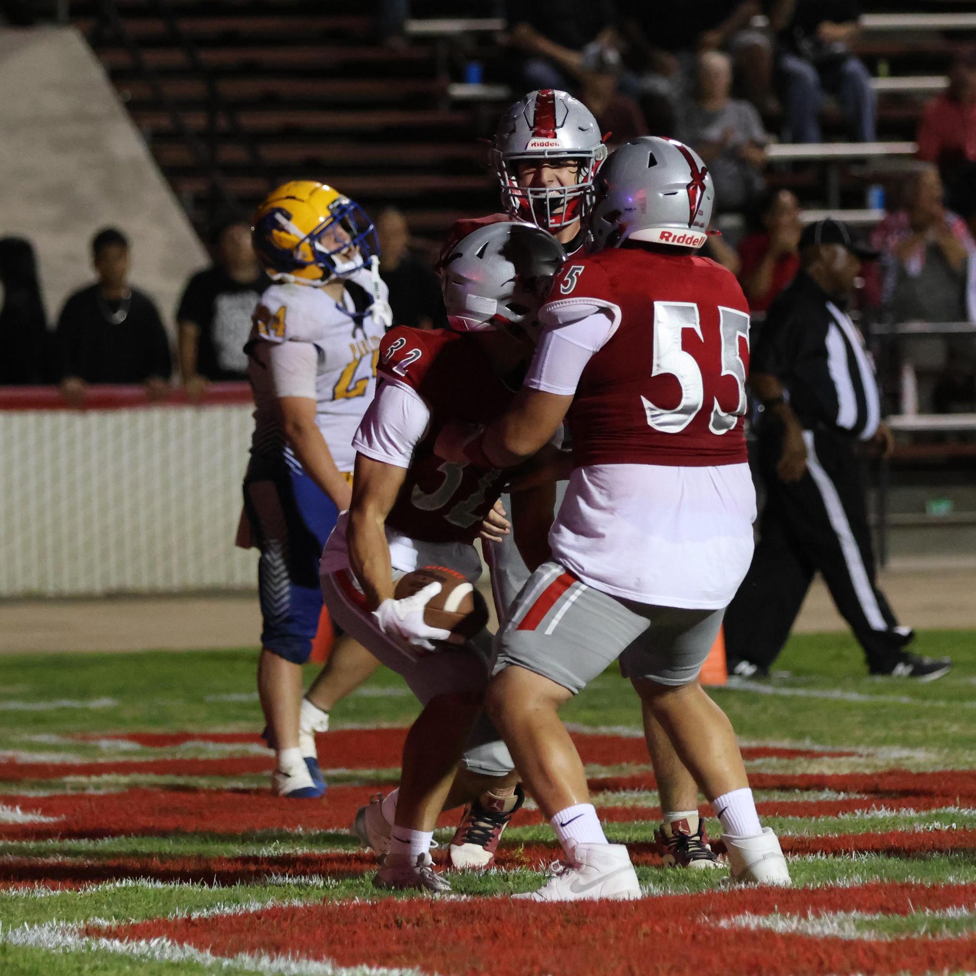 Varsity football players in action against Parlier 93
