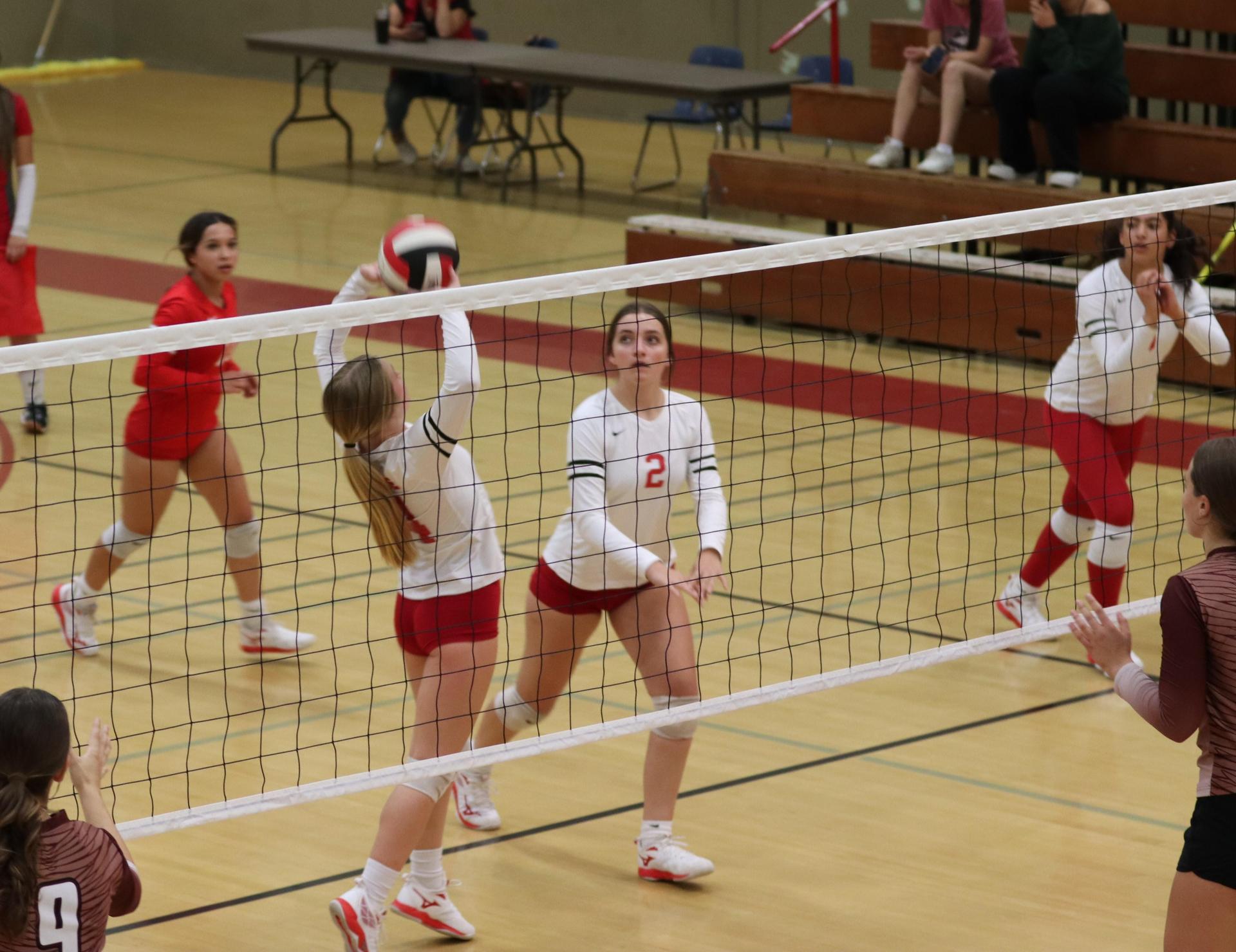 varsity volleyball players in action against Fresno Christian