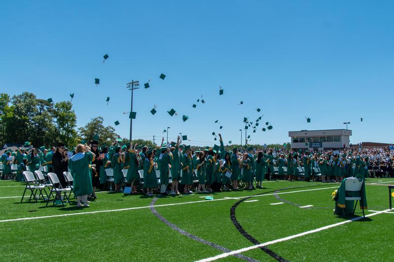 graduates toss their caps into the air