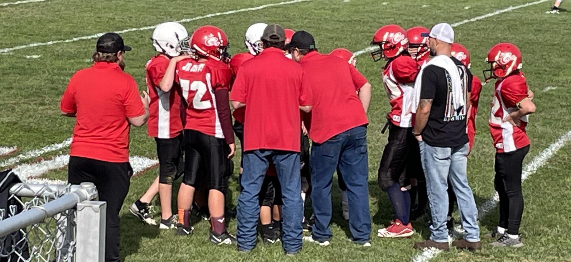Football players stand on a field.