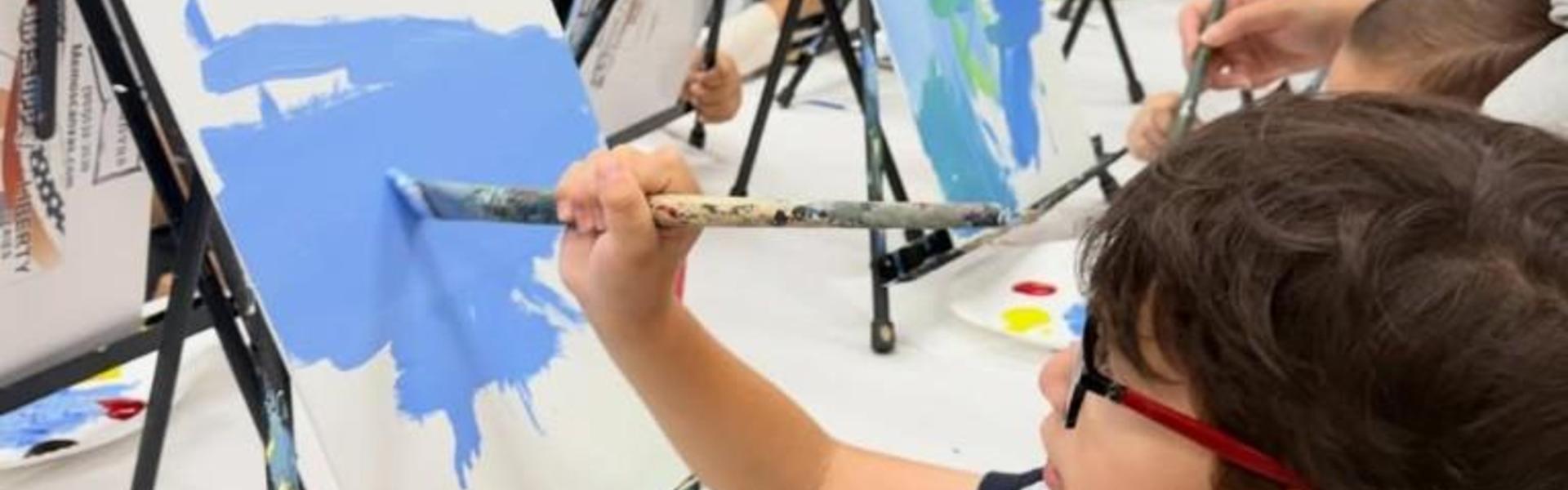 Children painting on easels with a variety of colors.