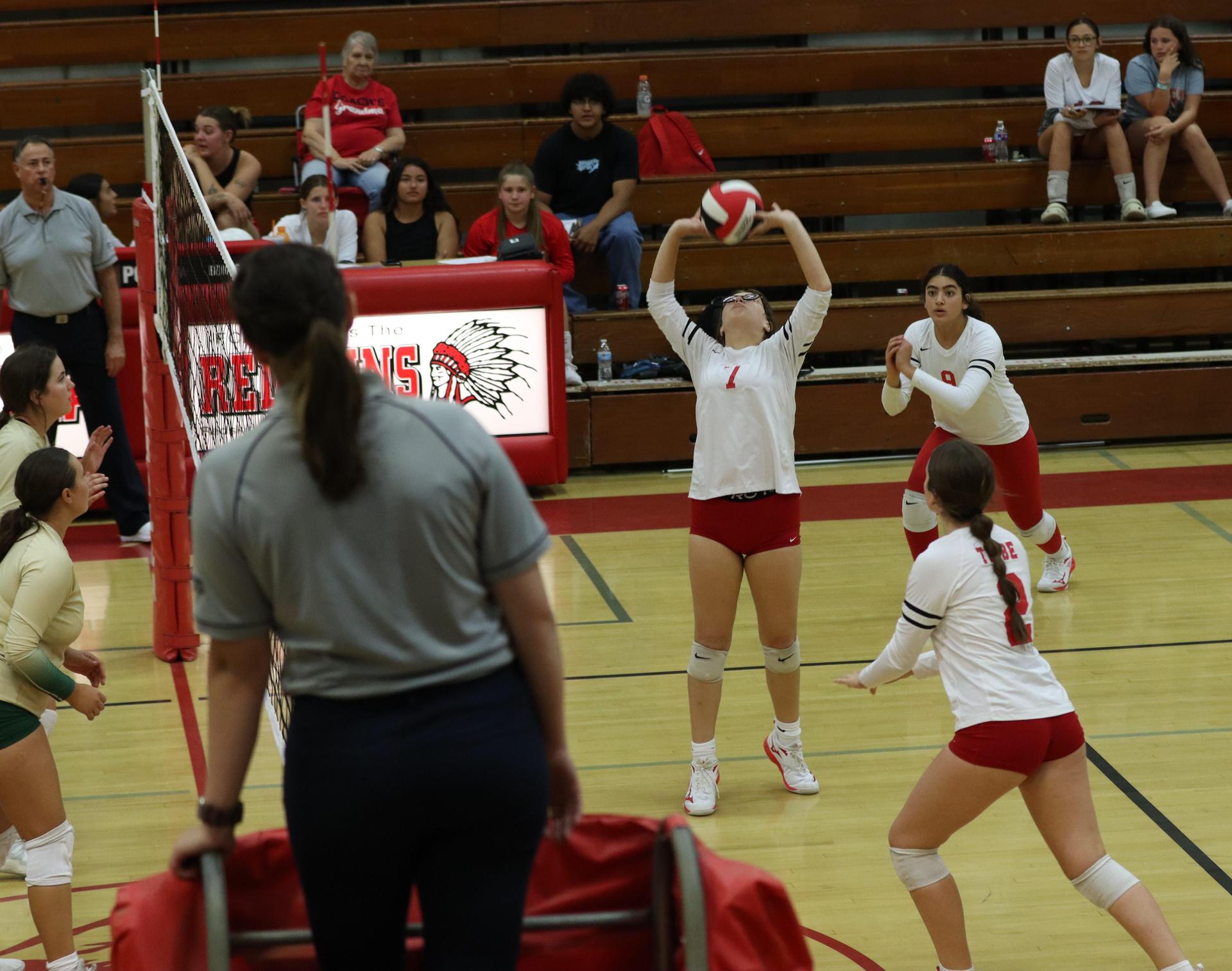 varsity volleyball players in action against liberty
